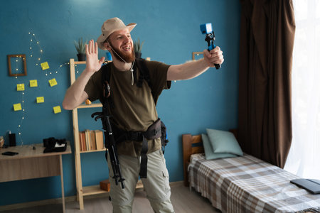 Young bearded man traveler recording video to small camera ready for hiking at home. backpacker travelの写真素材
