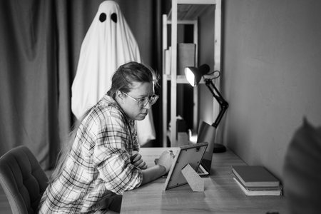Concept of afterlife and memory for lost love. Sad depressed woman looking photo frame while male ghost standing near her in the living room. Life and deathの写真素材