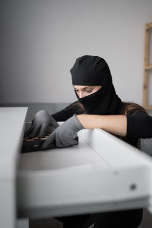 Female thief or burglar searching money stealing house. Criminal, house crime and breaking. Apartment, robbery and burglary on property.の写真素材