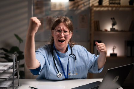 nurse working overtime on night shift with hands and aggressive angry gesture in hospital office. Health care and medicine serviceの写真素材