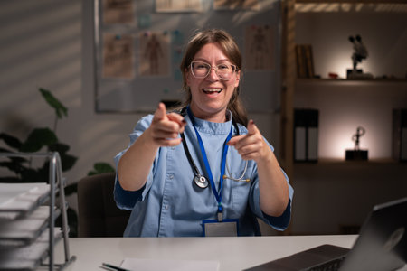 Tired stressed physician nurse working over hours at medical expertise in hospital office, typing patient report on computer. Assistant examining medication prescription. Health care serviceの写真素材