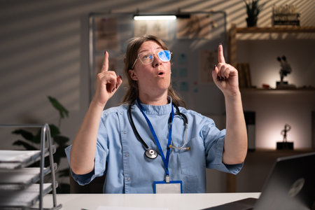 Tired stressed physician nurse working over hours at medical expertise in hospital office, typing patient report on computer. Assistant examining medication prescription. Health care serviceの写真素材