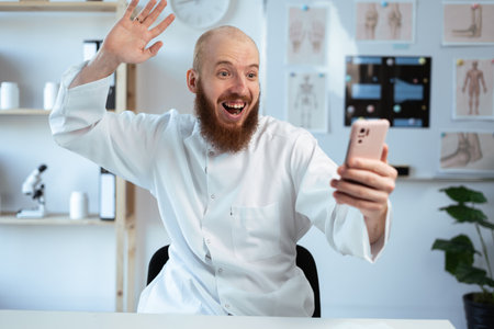 Excited happy doctor man winner using smartphone winning lottery getting cashback online working in hospital or medical clinicの写真素材