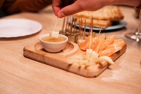 Appetizers. A slice of cheddar cheese dipped in honey. Cheese plate