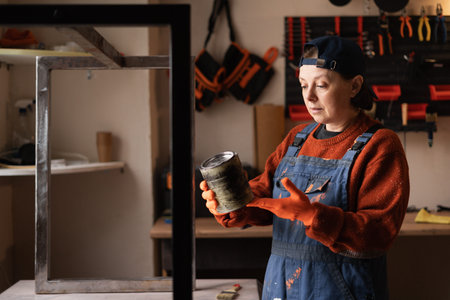 Smiling woman holding paint can renovating home garage interior