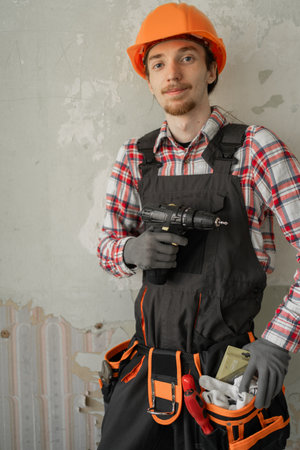 portrait of a construction worker holding drill and looking at camera. Construction and home improvement concept.の写真素材