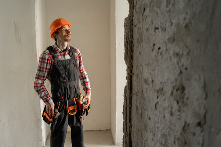 foreman in uniform builder at construction site. constructor in hardhat renovating apartment