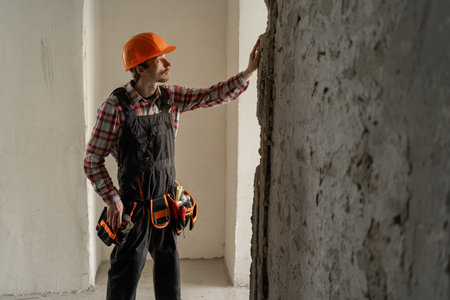 contractor builder with tool belt and hardhat inspection at construction site. worker and...