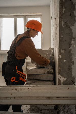 Female construction contractor carrying building debris while starting home renovation project