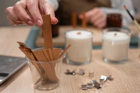 Preparing wooden wick for handmade candle, close-up. Woman holding wooden candle wick. candle-making processの写真素材