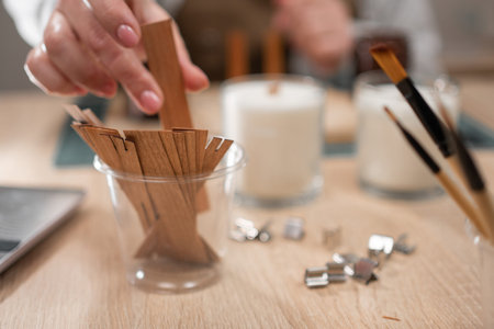 Preparing wooden wick for handmade candle, close-up. Woman holding wooden candle wick. candle-making processの写真素材