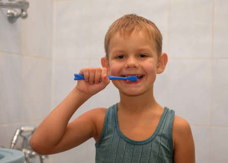 A boy of seven years old brushing his teeth in the bathroom before going to bedの写真素材