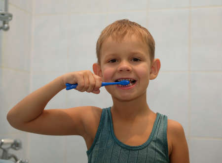 A boy of seven years old brushing his teeth in the bathroom before going to bedの写真素材