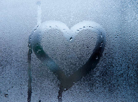 The picture in the heart on the sweaty glass of the windowの写真素材