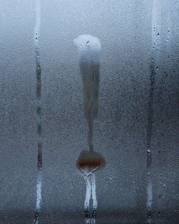 the exclamation mark on the misted glass with water dropsの写真素材