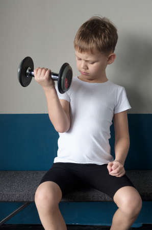 European boy seven years of experience in with a dumbbellの写真素材