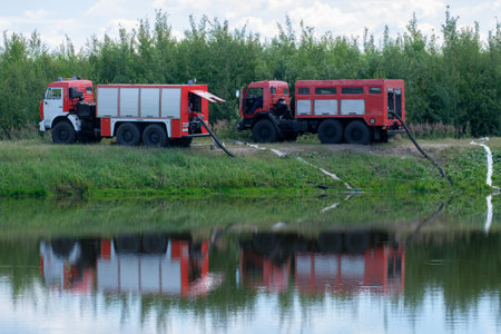 Two fire engines pump water from the pond