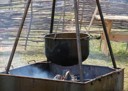 A large metal pot for cooking over the fireの写真素材