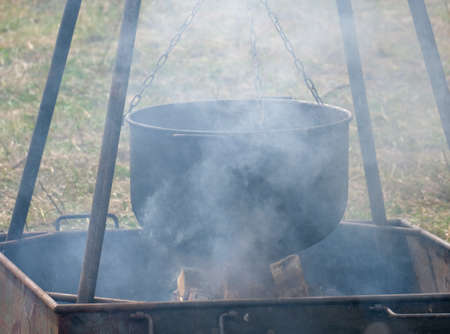A large metal pot for cooking over the fireの写真素材