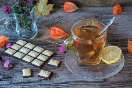 green tea in glass Cup and chocolate on wooden boards with autumn colorsの写真素材