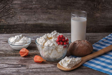 cheese, sour cream and milk in glass transparent bowl on old wooden Boardの写真素材