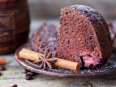 chocolate cupcake with strawberries and a large ceramic coffee mug on a wooden tableの写真素材