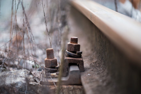 rusty nut and bolt on the rails of railway tracks