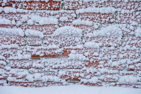 wall of red brick with adhering white snow. backgroundの写真素材