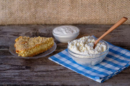 sour cream , cottage cheese in a glass container and a piece of the Royal tarts are homemade on wooden tableの写真素材