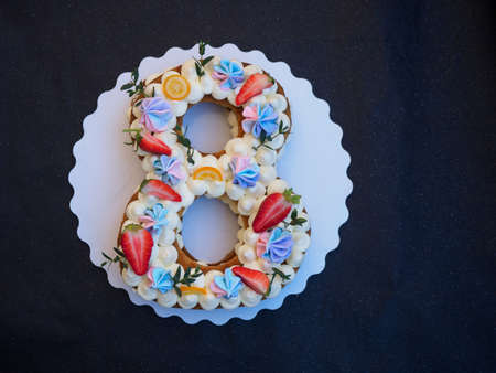 Homemade cake with cream and strawberries in the form of figures eightの写真素材