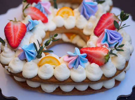 Homemade cake with cream and strawberries in the form of figures eightの写真素材