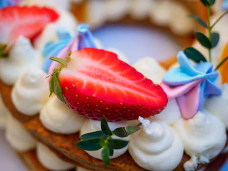 Homemade cake with cream and strawberries in the form of figures eightの写真素材