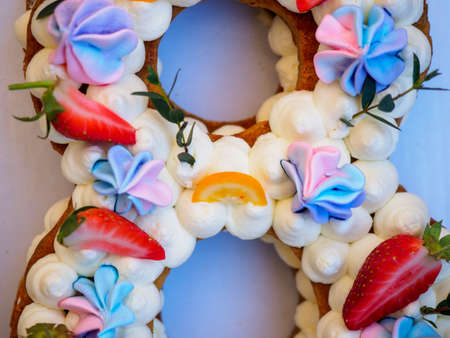 Homemade cake with cream and strawberries in the form of figures eightの写真素材