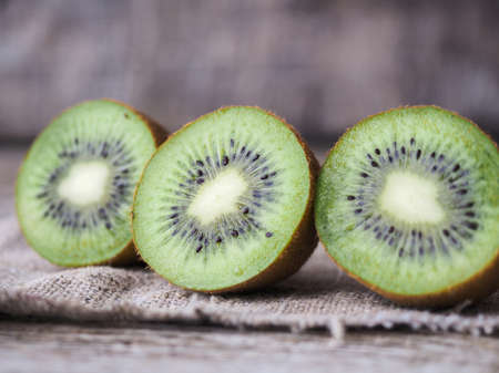 kiwi cut in half on a wooden tableの写真素材