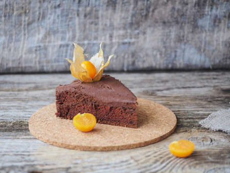 homemade sponge cake with chocolate-coconut cream and physalis on a wooden tableの写真素材