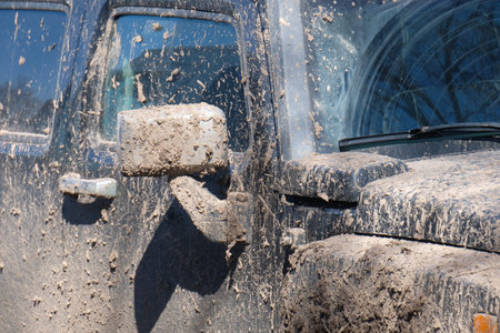 pieces of dirt on the glass, mirror and door of an off-road car