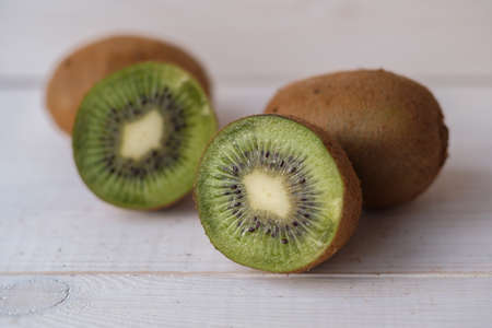 Sliced Kiwi Fruit on a White Wood Table in a Bright Kitchenの写真素材