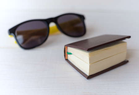 pocket book translator and sunglasses on white table. the concept of travelの写真素材
