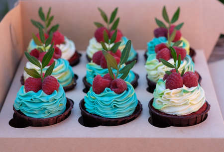 cupcakes with raspberries and cream cheese in a cardboard boxの写真素材