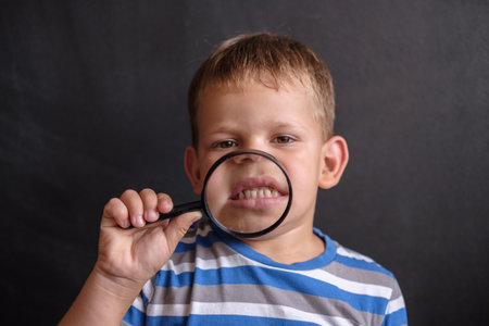 malocclusion in a boy of European appearance. look through a magnifying glass