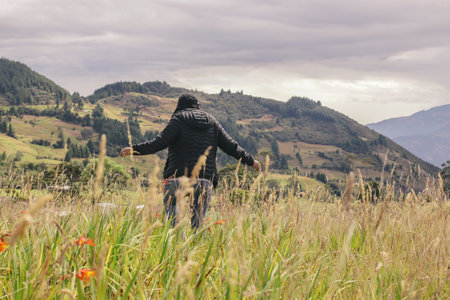 Young girl opening her arms in countryside landscape with sun from behind