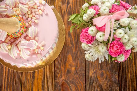 pink cake with a bouquet of flowersの写真素材