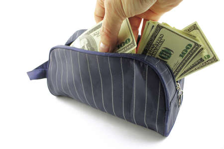 A hand takes out paper dollars from a purse on a white background. Crisis and economy concept. Close-up.の写真素材