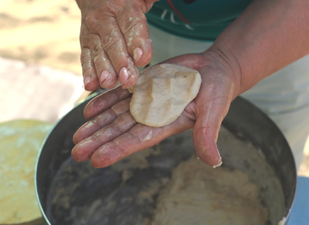 woman's hand close-up. dough in his hands and does pizza. in the pan is big doughの写真素材
