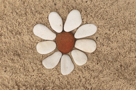 flower stone, lying on the sand. made of white pebbles and red. for designers and printの写真素材