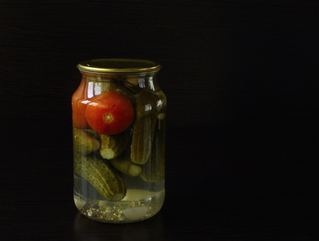 tasty and healthy food for your healthcucumbers and tomatoes in a glass jar. dark backgroundの写真素材