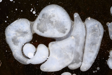 Air bubbles in the thickness of ice. Large, round and white.の写真素材