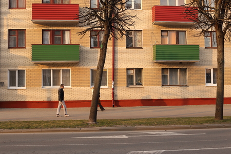 Facade of a residential building. Colored balconies. On the sidewalk there is a man. Spring 2015. The city of Togliatti. Editorialのeditorial素材