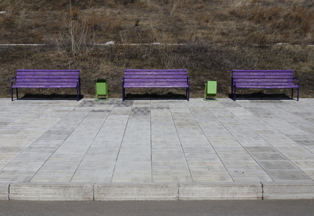 early spring on the street. There are three benches and two urns. stone pavementの写真素材
