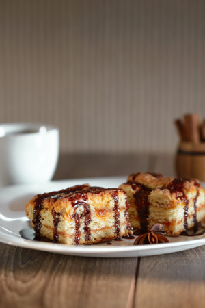 chocolate cake with black coffee on the wooden table, white dishes, cinnamon